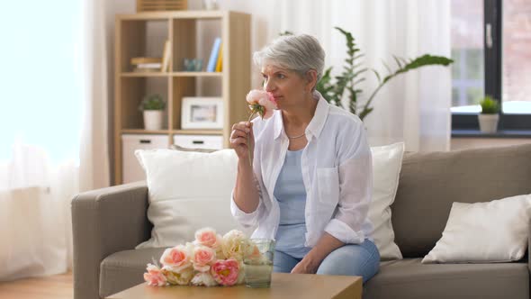 Happy Senior Woman Putting Flowers To Vase at Home 1