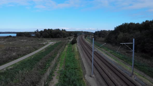 Empty railway track during Covid times which a blue sky on the background. Drone dolly shot