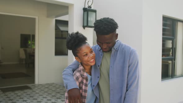 Video of happy african american couple embracing in front of new house