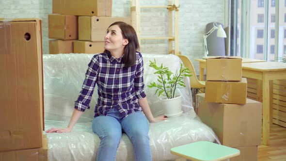 Joyful Woman Sitting on the Couch and Considering His New Modern Apartment