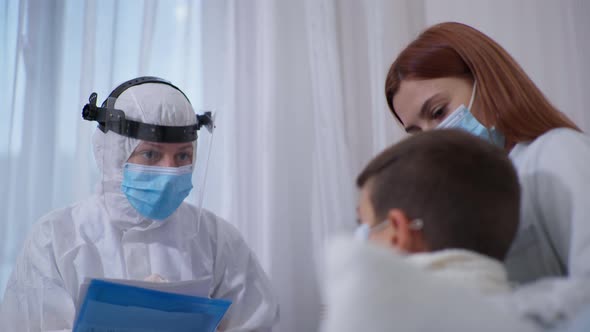 Doctor Wearing Safety Helmet, Medical Mask and Suit To Protect Against Virus and Infection Gives