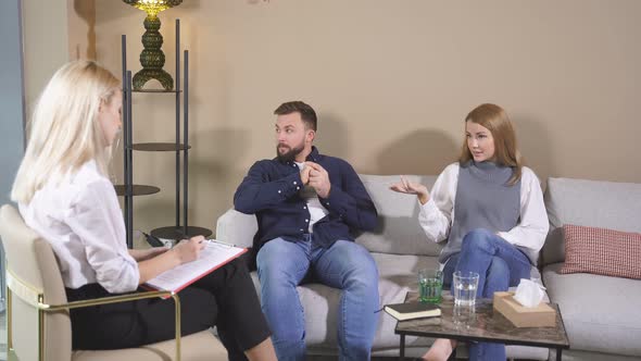 Woman Sharing Problems with Doctor Couple at Psychologist Therapy Session in Office