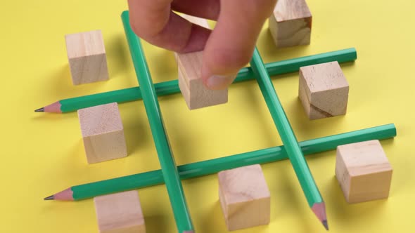 Business strategy concept. Creative game with pencils and wooden cubes on a bright yellow background