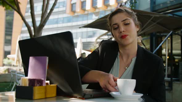 Young business woman sitting in a cafe working on a laptop computer