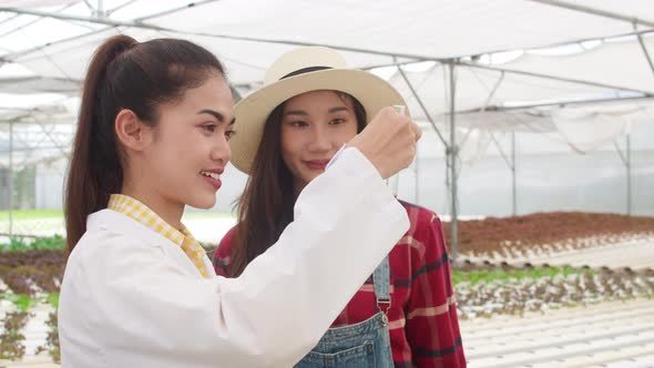 woman checking young plant healthy in organic farm and give knowledge how to take care the owner.