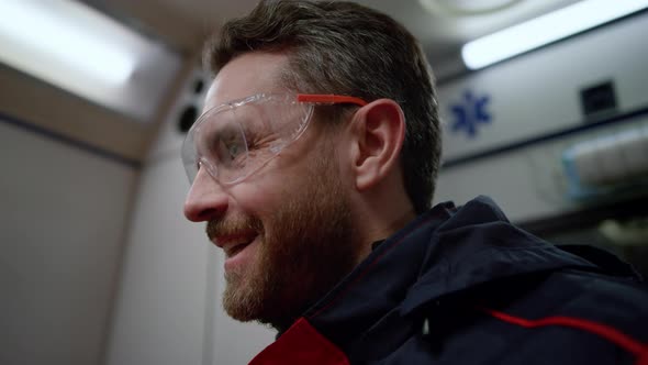 Smiling Ambulance Paramedic Talking with Colleague in Emergency Car