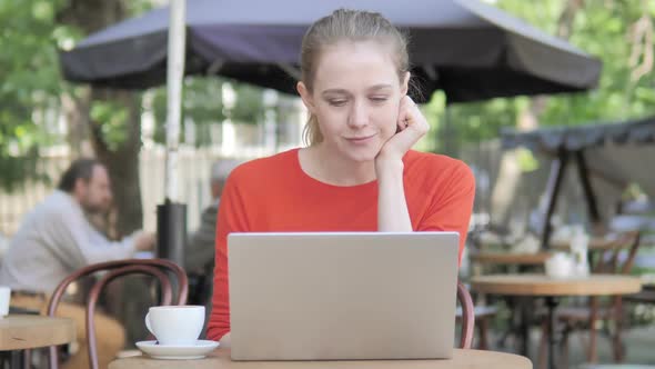 Young Woman Working on Laptop While Sitting in Cafe Terrace