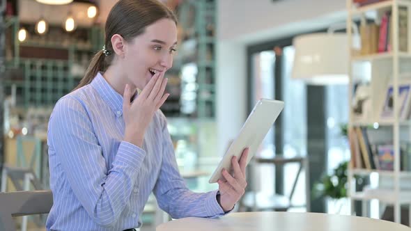 Young Businesswoman Celebrating on Tablet in Cafe Success