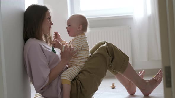 Little Baby Girl and Mommy Playing at Home Sitting on Floor