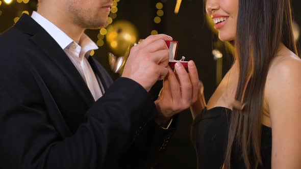Young Man Presenting Diamond Ring to Girlfriend, Proposing at Party, Marriage