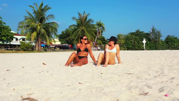 Girls posing on marine tourist beach journey by turquoise sea and white sandy background of Koh Phan