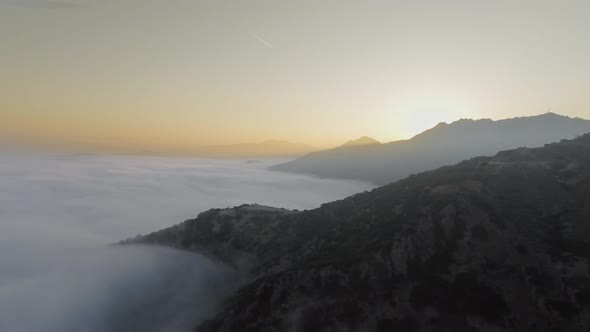 Canyon, clouds and a trail in the sky from the plane in Malibu Canyon, Calabasas, California, USA