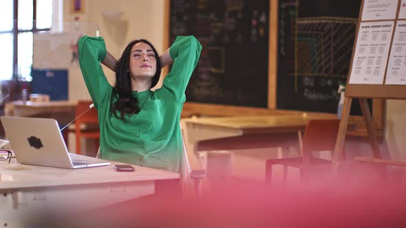 Businesswoman sitting in office, relaxing with eyes closed