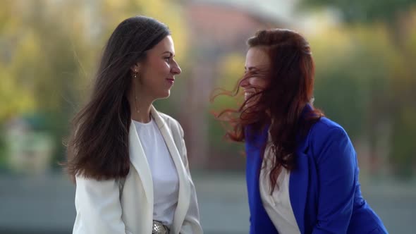 Communication of Two Female Friends at Walking Outdoors in City