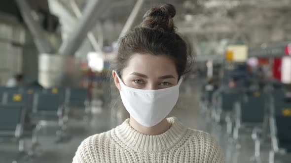 End of Pandemic. Portrait of Woman Put Off Medical Mask Looking Straight at Camera in Airport