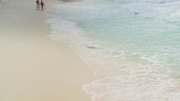 Elderly Couple Walking Towards Camera Along Beach Part Ii