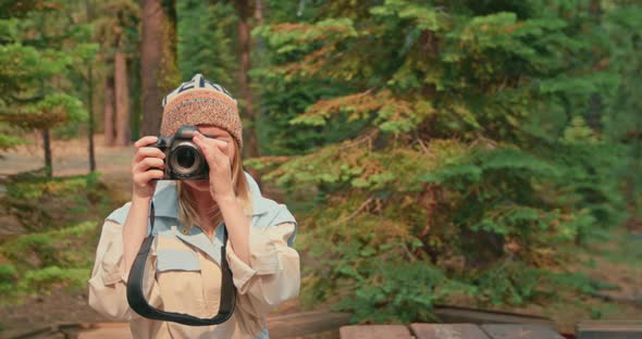 Woman Taking Picture of Autumn Forest on Camera. Beautiful Traveler in Nature