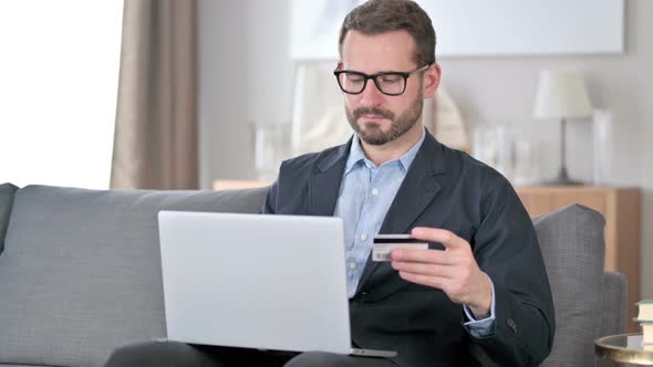 Successful Online Payment on Laptop By Young Man