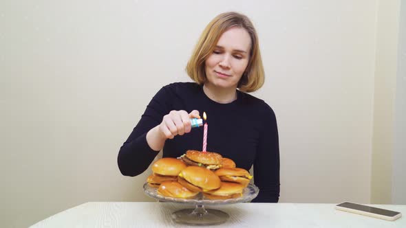 a Woman Lights Candles and Makes a Wish on a Hamburger Cake