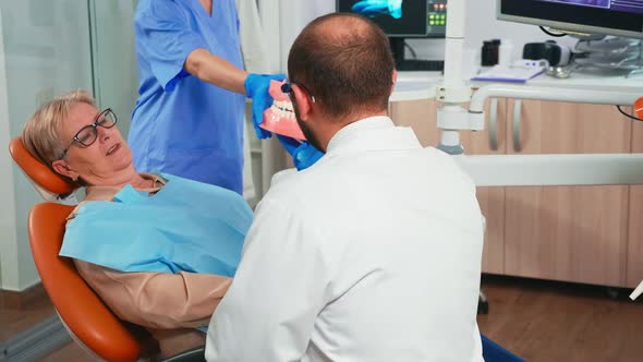 Dentist Holding the Dental Jaw Speaking with Patient