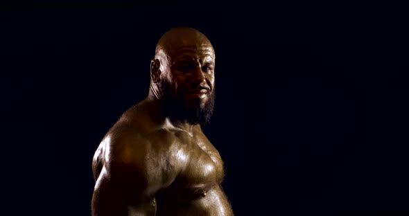 Portrait of a Bearded Bald Brutal Male Bodybuilder with a Naked Inflated Torso, He Is in the Studio