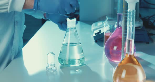 Slow motion of lab Technician mixing chemicals in a lab