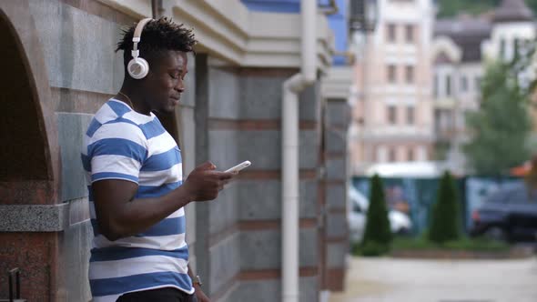 Man with Headphones Listening Music on Smart Phone