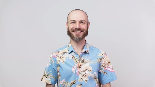 Portrait of a smiling man wearing hawaiian shirt over white background