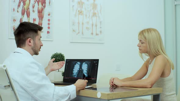 Friendly Doctor Man Giving Good News Pulmonary XRay Woman Patient in Hospital Indoor