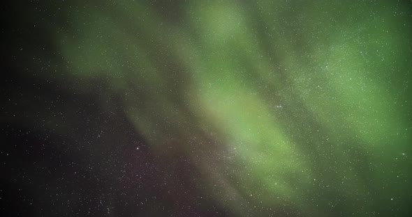 Aurora Borealis timelapse of strong green northern lights display dancing in night sky. Time lapse i
