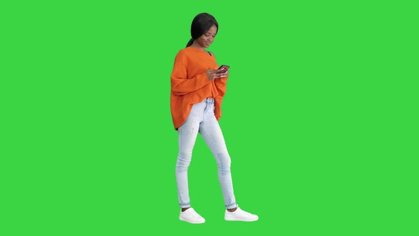 A Beautiful Young Woman Using Her Phone on a Green Screen, Chroma Key.