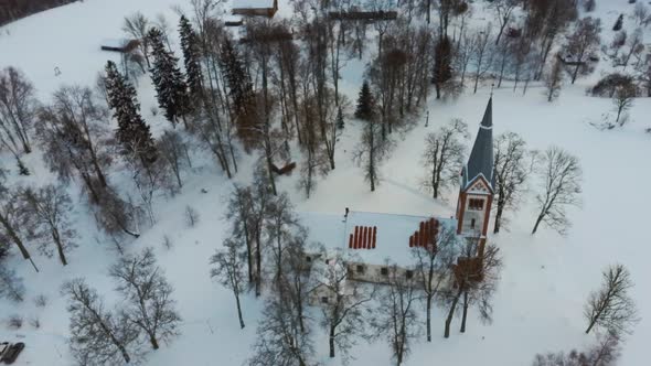 Aerial Top View of the Krimulda Evangelic Lutheran Church in Winter at Sunrise Latvia 4k Video