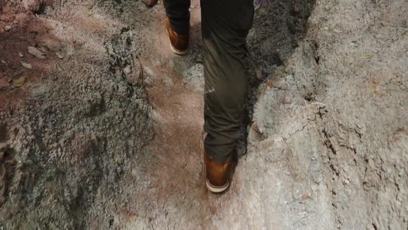 slow-motion of legs of young hiker walking on the rock path