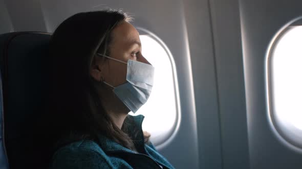 Woman Looking Through the Window in the Airplane