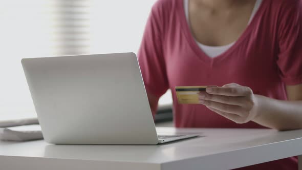 Asian woman hand holding credit card payment using laptop shopping online.