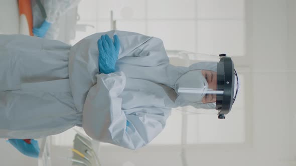 Vertical Video Portrait of Dentist Standing in Hazmat Suit for Virus Protection