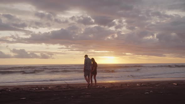 Couple Walking on Beach at Sunset