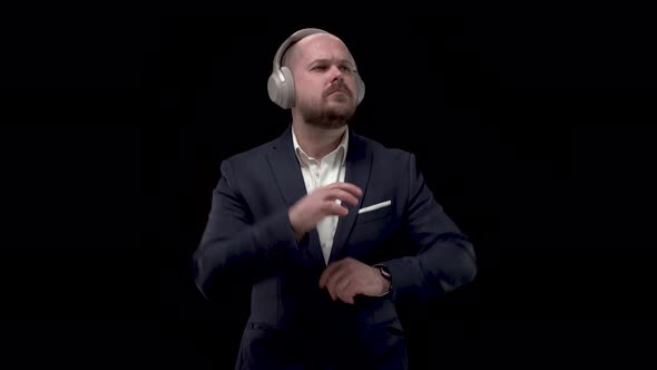Bald Bearded Handsome Businessman, Man in Blue Jacket and White Shirt in Headphones, Rejoices in