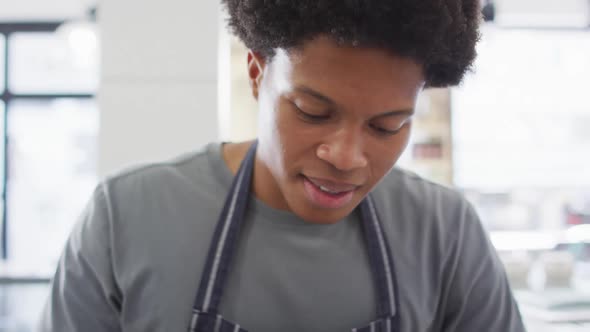 Animation of happy biracial waiter using meat cutting machine