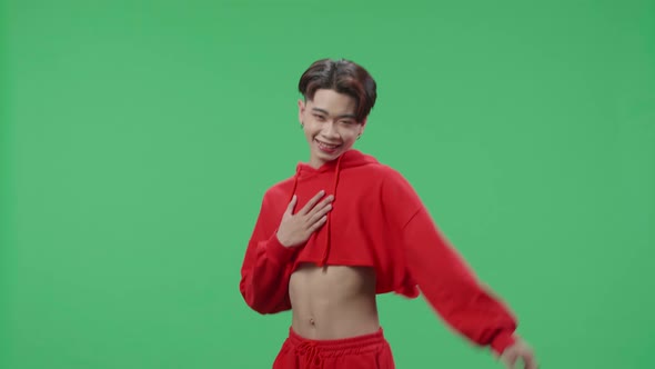 The Smiling Asian Transgender Male Dancing While Standing On Green Screen Studio