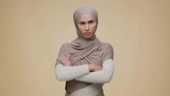 Portrait of Young Offended Middle Eastern Lady Wearing Traditional Hijab Posing with Folded Arms and