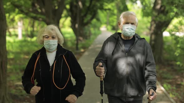 Active Senior Old Man, Woman Training Nordic Walking in Park During Quarantine