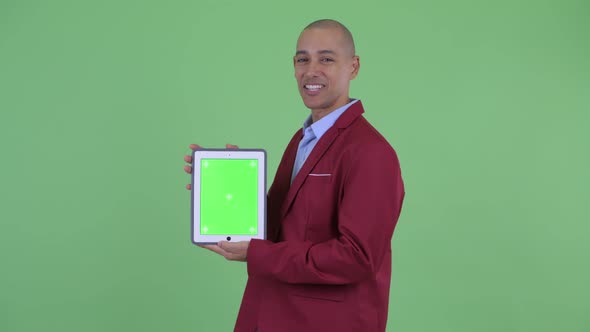 Happy Bald Multi Ethnic Businessman Talking While Showing Digital Tablet