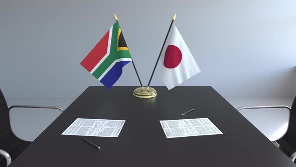 Flags of South Africa and Japan and Papers on the Table