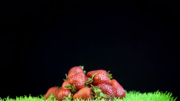 A pile of strawberries isolated on a dark backdrop