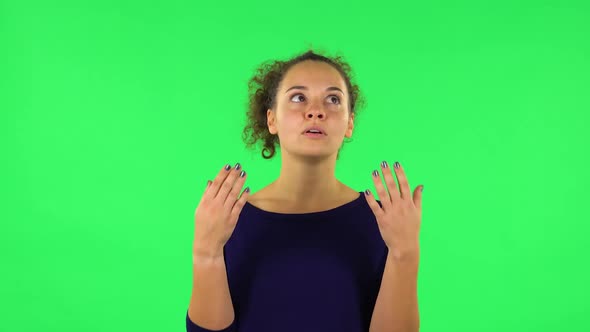 Portrait of Curly Woman Cooling Herself By Her Hand, Suffering From High Temperature Weather. Green