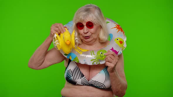 Senior Woman Tourist in Sunglasses Dancing Playing with Inflatable Duck Toy Rubber Swimming Ring