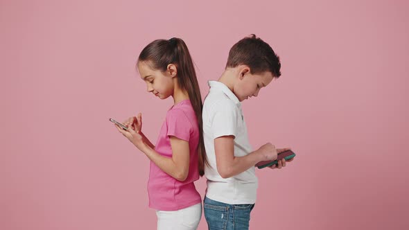 Little Brother and Sister Networking Online on Smartphones Ignoring Real Communication Standing Back