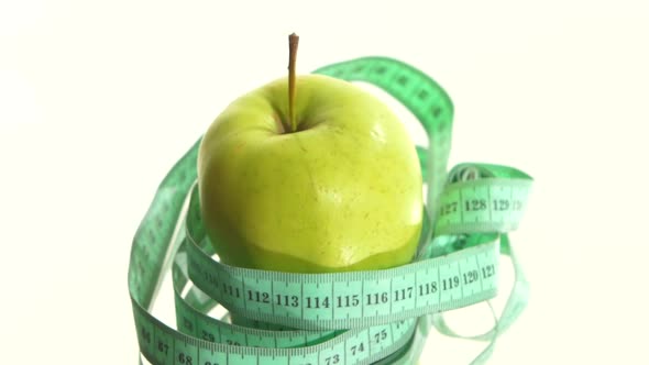 Green, Fresh Apple with Measuring Tape on White, Rotation, Reflection