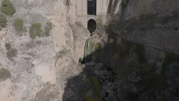 Aerial tilt reveals huge arch bridge over deep narrow canyon in Spain